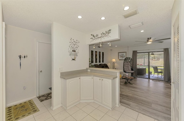 4044 S Salford Blvd, North Port, FL 34287 - kitchen with a peninsula, open floor plan, a textured ceiling, ceiling fan, and light tile patterned floors