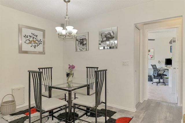 4044 S Salford Blvd, North Port, FL 34287 - dining space featuring wood finished floors, a chandelier, an office area, a textured ceiling, and baseboards