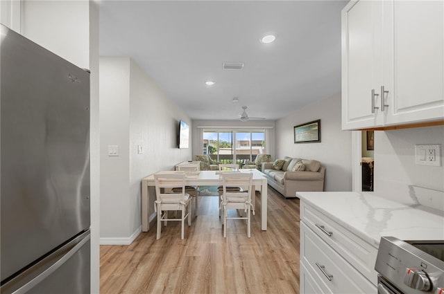 1080 Bal Harbor Blvd Unit 12C, Punta Gorda, FL 33950 - kitchen featuring freestanding refrigerator, light wood-style flooring, light stone countertops, white cabinetry, and recessed lighting