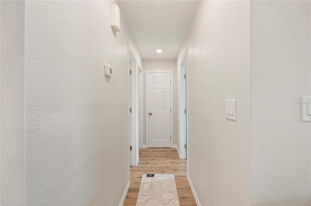 1080 Bal Harbor Blvd Unit 12C, Punta Gorda, FL 33950 - hall featuring light wood-type flooring, baseboards, a textured wall, and recessed lighting