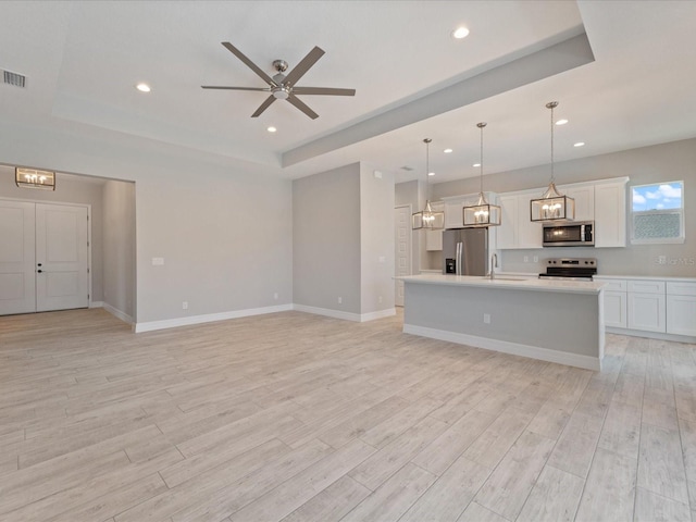 223 Australian Dr, Rotonda West, FL 33947 - unfurnished living room featuring a raised ceiling, a sink, light wood finished floors, recessed lighting, and a ceiling fan