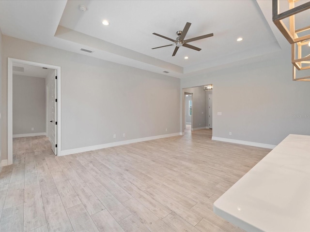 223 Australian Dr, Rotonda West, FL 33947 - spare room with a tray ceiling, a ceiling fan, light wood-type flooring, baseboards, and recessed lighting