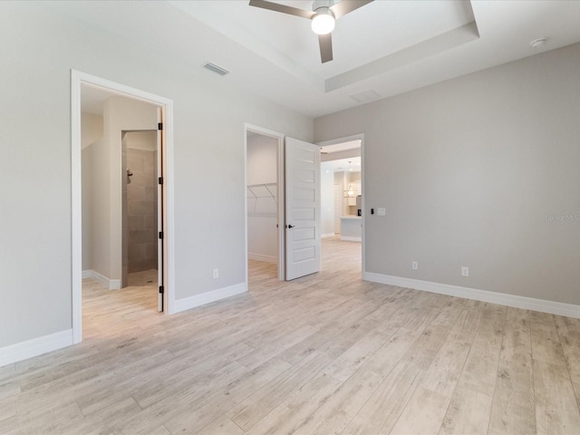 223 Australian Dr, Rotonda West, FL 33947 - unfurnished bedroom with a walk in closet, light wood-style floors, a closet, and baseboards