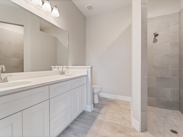 223 Australian Dr, Rotonda West, FL 33947 - full bath featuring toilet, double vanity, a walk in shower, wood finished floors, and baseboards