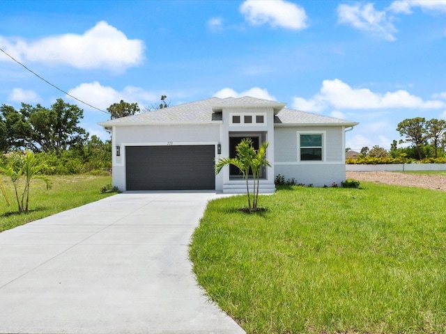 223 Australian Dr, Rotonda West, FL 33947 - prairie-style house featuring a garage, a front yard, concrete driveway, and stucco siding