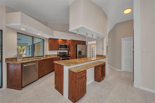 2442 Rio De Janeiro Ave, Punta Gorda, FL 33983 - kitchen with stainless steel appliances, a peninsula, a sink, light stone counters, and light tile patterned floors