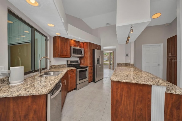 2442 Rio De Janeiro Ave, Punta Gorda, FL 33983 - kitchen featuring appliances with stainless steel finishes, a sink, a peninsula, light tile patterned floors, and light stone counters
