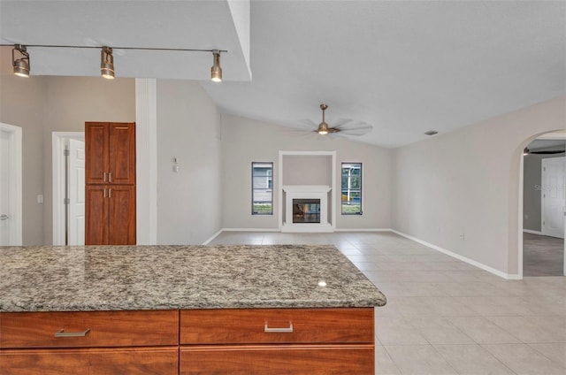 2442 Rio De Janeiro Ave, Punta Gorda, FL 33983 - kitchen featuring light tile patterned floors, ceiling fan, arched walkways, light stone countertops, and lofted ceiling