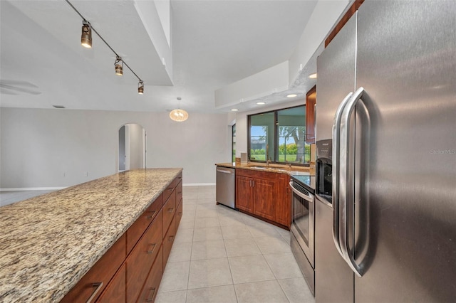 2442 Rio De Janeiro Ave, Punta Gorda, FL 33983 - kitchen featuring stainless steel appliances, light stone countertops, arched walkways, light tile patterned floors, and baseboards