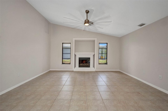 2442 Rio De Janeiro Ave, Punta Gorda, FL 33983 - unfurnished living room featuring light tile patterned floors, vaulted ceiling, a ceiling fan, a glass covered fireplace, and baseboards