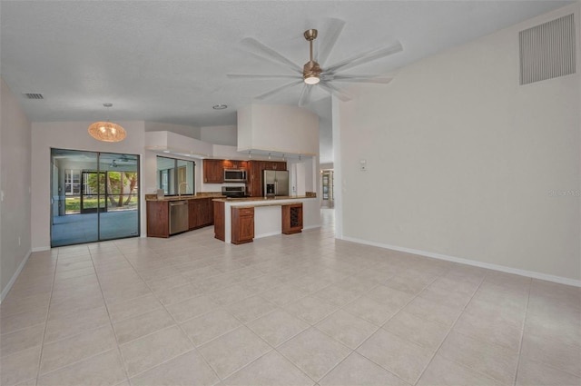 2442 Rio De Janeiro Ave, Punta Gorda, FL 33983 - kitchen featuring appliances with stainless steel finishes, open floor plan, lofted ceiling, light countertops, and a ceiling fan