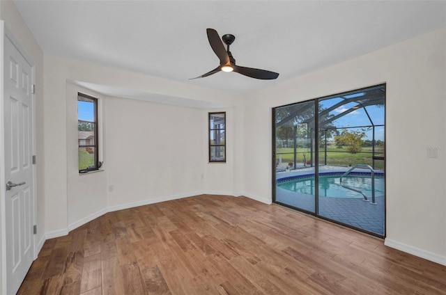 2442 Rio De Janeiro Ave, Punta Gorda, FL 33983 - unfurnished bedroom with access to exterior, wood finished floors, a sunroom, and baseboards