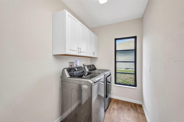 2442 Rio De Janeiro Ave, Punta Gorda, FL 33983 - laundry room featuring washer and clothes dryer, cabinet space, baseboards, and light wood-style flooring