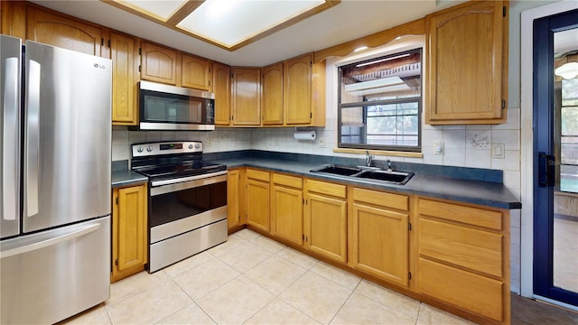 4071 Dekle Ave, North Port, FL 34286 - kitchen featuring stainless steel appliances, dark countertops, light tile patterned floors, tasteful backsplash, and brown cabinets