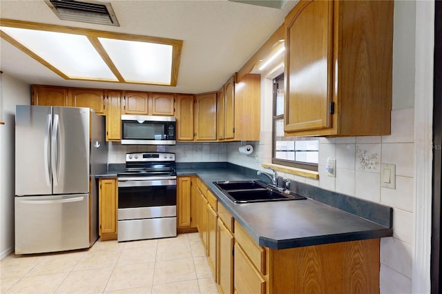 4071 Dekle Ave, North Port, FL 34286 - kitchen with appliances with stainless steel finishes, dark countertops, brown cabinetry, and decorative backsplash