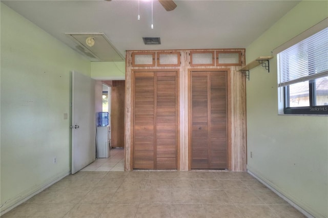 4071 Dekle Ave, North Port, FL 34286 - unfurnished bedroom with two closets, light tile patterned flooring, and attic access