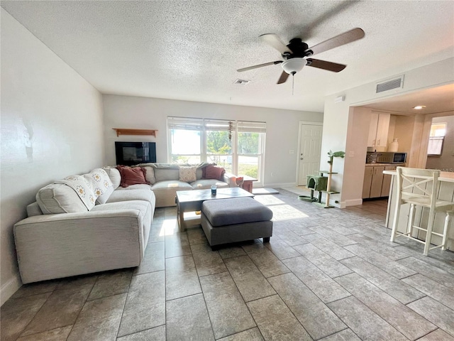 3122 Scranton St, Port Charlotte, FL 33952 - living area featuring ceiling fan, healthy amount of natural light, a textured ceiling, and baseboards