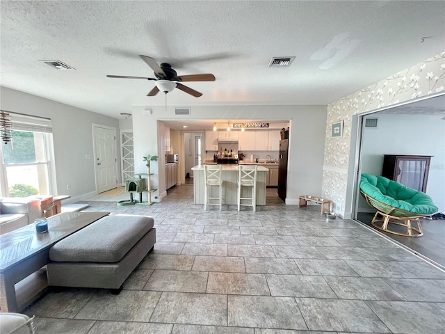 3122 Scranton St, Port Charlotte, FL 33952 - living area featuring baseboards, ceiling fan, and a textured ceiling