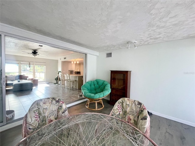 3122 Scranton St, Port Charlotte, FL 33952 - living room with a textured ceiling, baseboards, wood finished floors, and a ceiling fan