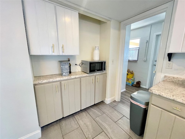 3122 Scranton St, Port Charlotte, FL 33952 - kitchen with stainless steel microwave, baseboards, and white cabinets