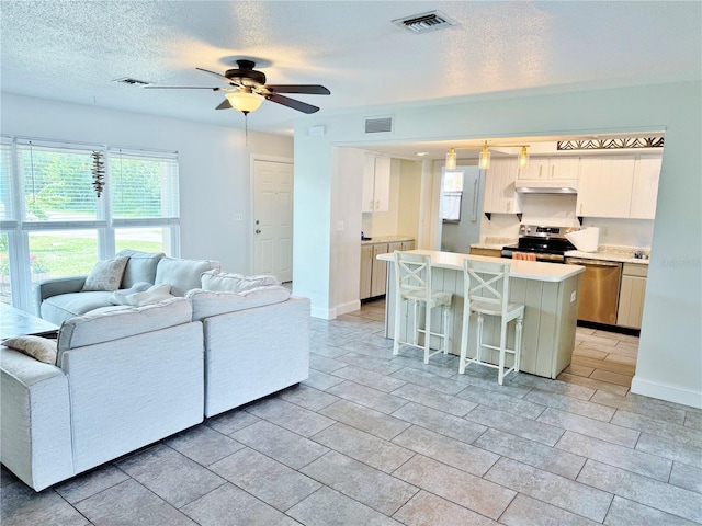 3122 Scranton St, Port Charlotte, FL 33952 - living room featuring ceiling fan, healthy amount of natural light, and a textured ceiling