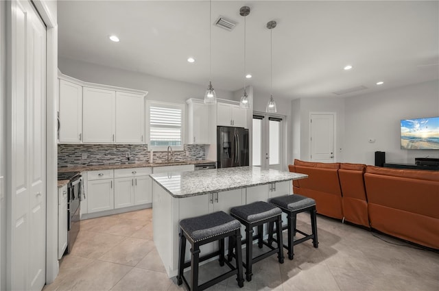 3302 Palm Dr, Punta Gorda, FL 33950 - kitchen featuring black appliances, a sink, open floor plan, backsplash, and a center island
