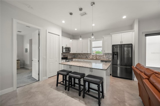 3302 Palm Dr, Punta Gorda, FL 33950 - kitchen with appliances with stainless steel finishes, a center island, tasteful backsplash, white cabinetry, and recessed lighting