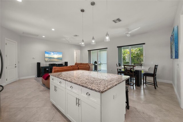 3302 Palm Dr, Punta Gorda, FL 33950 - kitchen with a center island, light stone countertops, baseboards, white cabinets, and recessed lighting