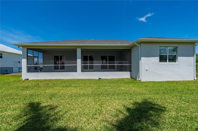 3302 Palm Dr, Punta Gorda, FL 33950 - rear view of property featuring a sunroom, a yard, and stucco siding