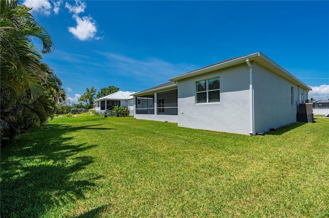3302 Palm Dr, Punta Gorda, FL 33950 - rear view of property featuring stucco siding, a lawn, and a sunroom