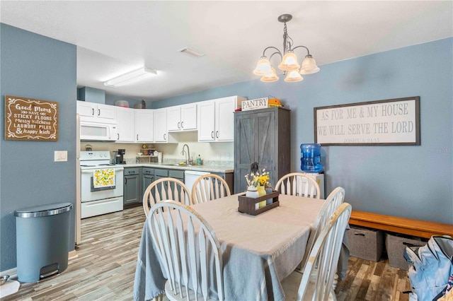 4702 Westwood Dr, Punta Gorda, FL 33982 - dining area with light wood-style floors and a chandelier