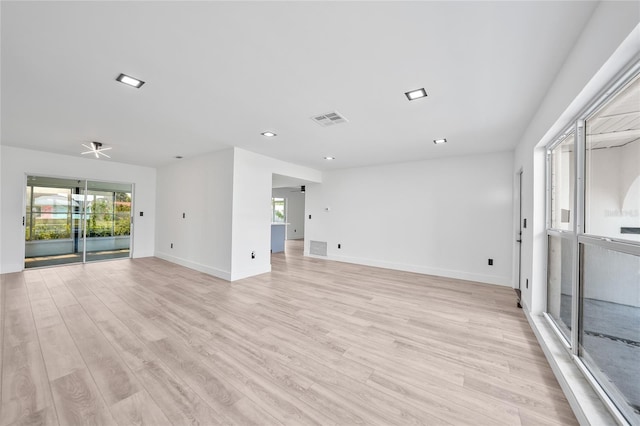 2166 Beacon Dr, Port Charlotte, FL 33952 - unfurnished living room featuring healthy amount of natural light, light wood-type flooring, baseboards, and recessed lighting