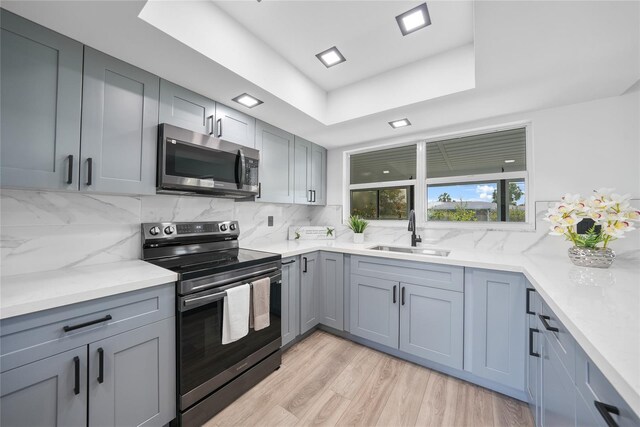 2166 Beacon Dr, Port Charlotte, FL 33952 - kitchen featuring stainless steel appliances, a sink, a raised ceiling, and backsplash