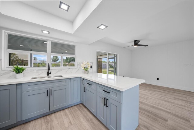 2166 Beacon Dr, Port Charlotte, FL 33952 - kitchen with a sink, a peninsula, light wood-style floors, and ceiling fan