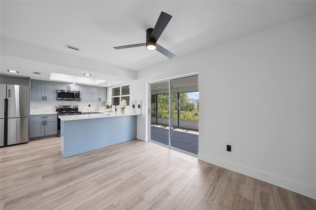 2166 Beacon Dr, Port Charlotte, FL 33952 - kitchen featuring appliances with stainless steel finishes, light countertops, a sink, a peninsula, and gray cabinetry