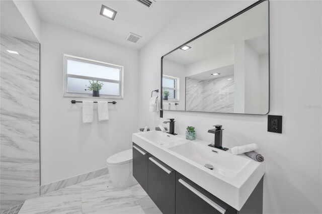 2166 Beacon Dr, Port Charlotte, FL 33952 - full bathroom featuring toilet, double vanity, marble look tile flooring, and baseboards