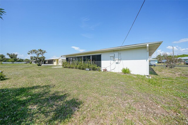 2166 Beacon Dr, Port Charlotte, FL 33952 - rear view of property with a lawn and stucco siding
