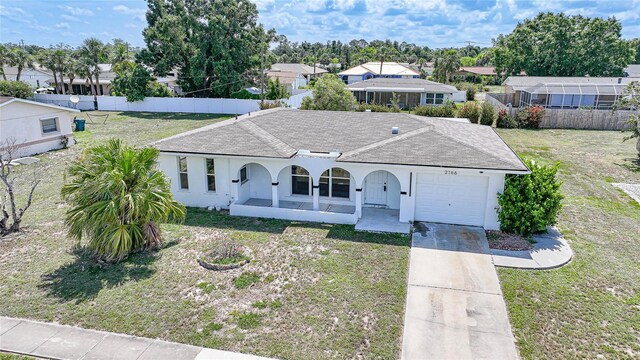 2166 Beacon Dr, Port Charlotte, FL 33952 - ranch-style house with an attached garage, roof with shingles, covered porch, driveway, and a residential view
