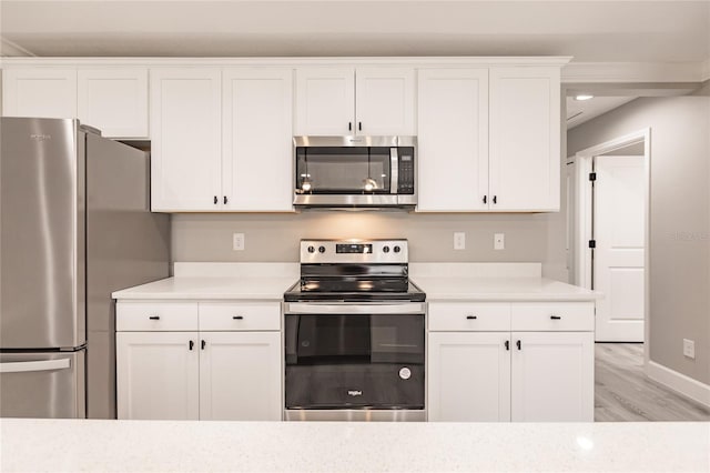 16280 Minorca Dr, Punta Gorda, FL 33955 - kitchen with appliances with stainless steel finishes, light countertops, light wood-style floors, white cabinetry, and baseboards
