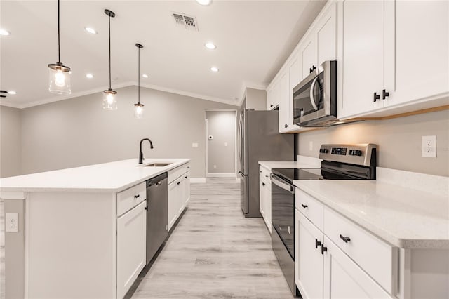 16280 Minorca Dr, Punta Gorda, FL 33955 - kitchen featuring appliances with stainless steel finishes, a sink, crown molding, a center island with sink, and white cabinetry