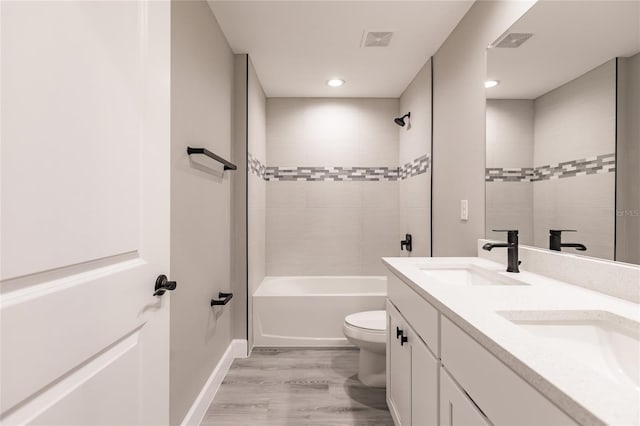 16280 Minorca Dr, Punta Gorda, FL 33955 - bathroom featuring toilet, wood finished floors, double vanity, bathtub / shower combination, and baseboards