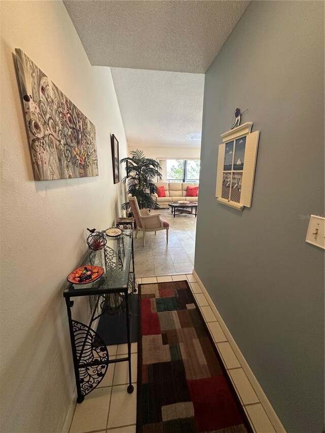4120 SE 19th Pl Unit 202, Cape Coral, FL 33904 - hallway featuring a textured ceiling, tile patterned flooring, and baseboards