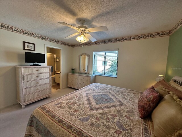 4120 SE 19th Pl Unit 202, Cape Coral, FL 33904 - bedroom with a textured ceiling, light colored carpet, connected bathroom, and a ceiling fan