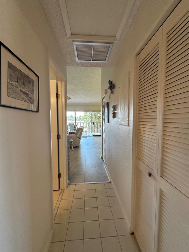 4120 SE 19th Pl Unit 202, Cape Coral, FL 33904 - hallway featuring light tile patterned floors, baseboards, and a textured ceiling