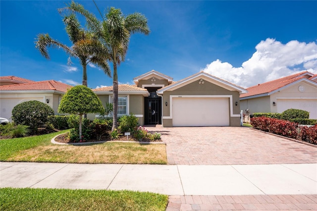 11666 Parrotfish St, Venice, FL 34292 - ranch-style home featuring a garage, decorative driveway, stucco siding, a front yard, and a tiled roof