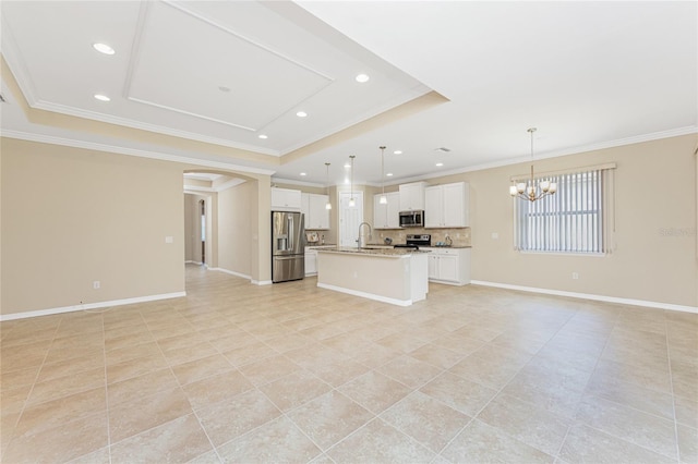 11666 Parrotfish St, Venice, FL 34292 - kitchen with appliances with stainless steel finishes, open floor plan, a raised ceiling, ornamental molding, and a center island with sink