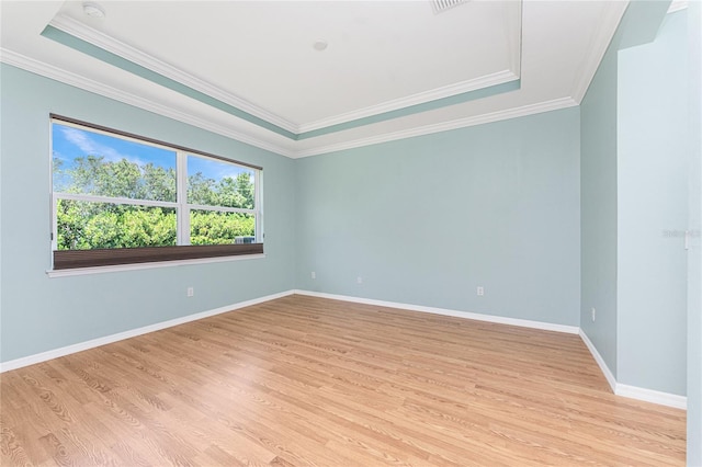 11666 Parrotfish St, Venice, FL 34292 - empty room with a tray ceiling, light wood-type flooring, ornamental molding, and baseboards
