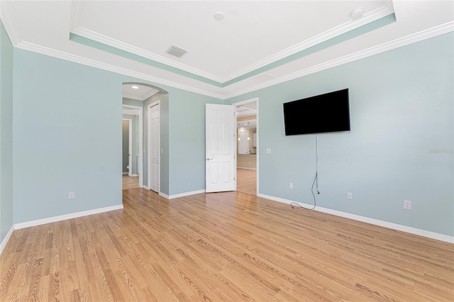 11666 Parrotfish St, Venice, FL 34292 - spare room featuring arched walkways, crown molding, light wood-style floors, a tray ceiling, and baseboards