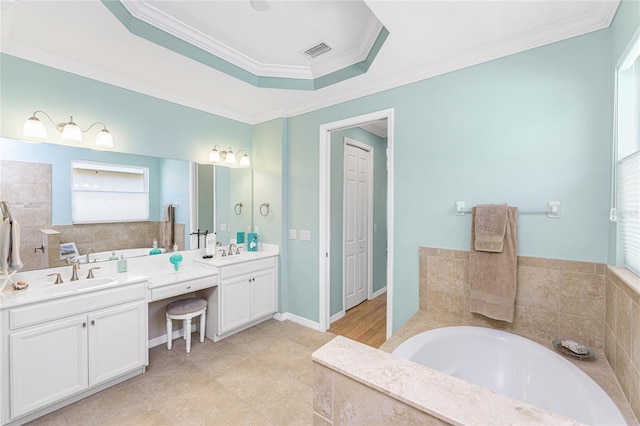 11666 Parrotfish St, Venice, FL 34292 - bathroom with double vanity, a garden tub, ornamental molding, and a tray ceiling
