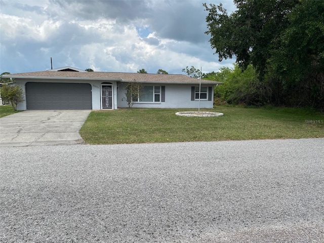 23220 Rountree Ave, Port Charlotte, FL 33980 - ranch-style home featuring an attached garage, concrete driveway, a front yard, and stucco siding
